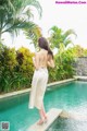 A woman standing on the edge of a swimming pool.