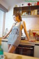 A woman standing in a kitchen next to a counter.