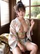 A woman in a kimono sitting on a window sill.