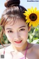 A young woman with a sunflower in her hair.