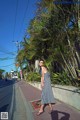 A woman in a black and white dress is walking down the street.