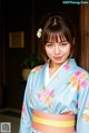 A woman in a blue kimono with a flower in her hair.