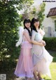 Two young women standing next to each other in dresses.